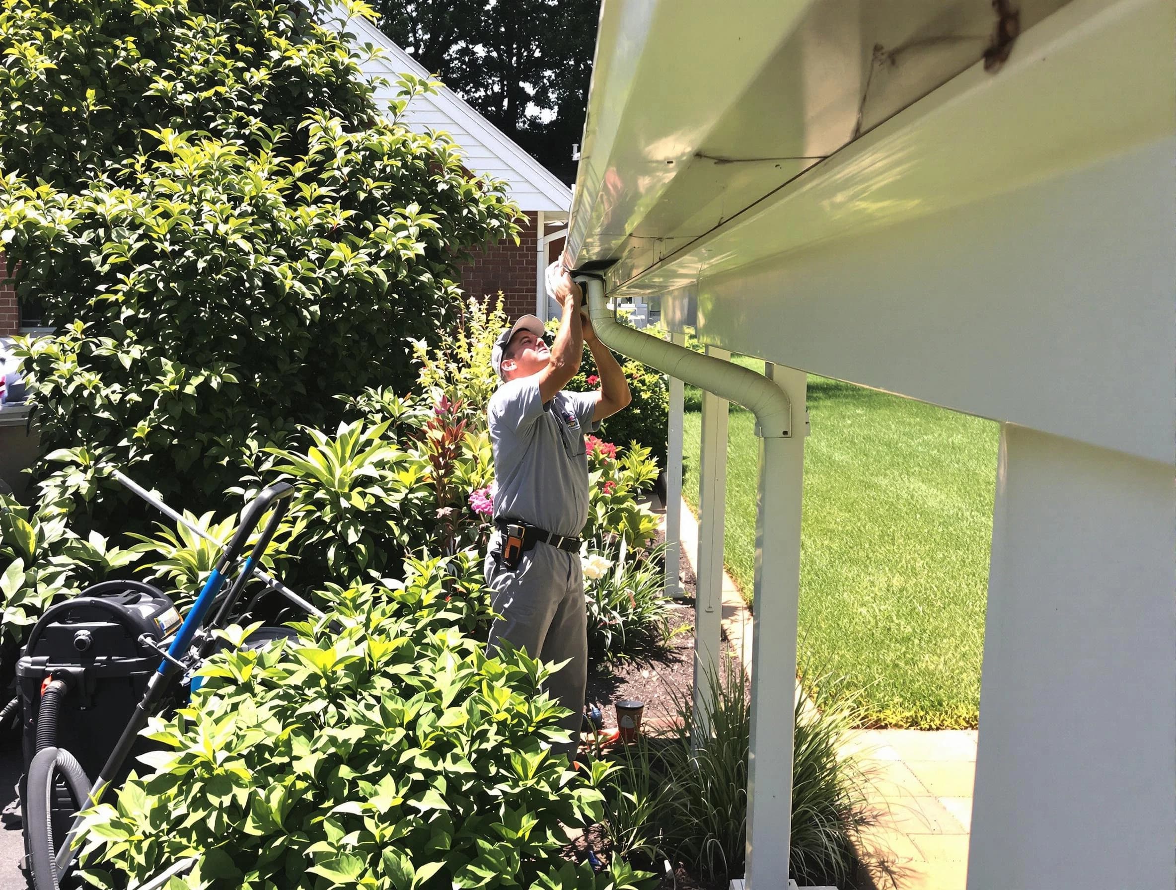 Technician flushing a blockage from a downspout in Bay Village, OH